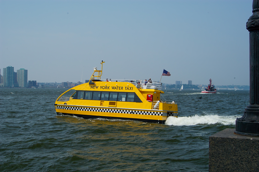 vibrant yellow new york water taxi cuts through the blue waves o