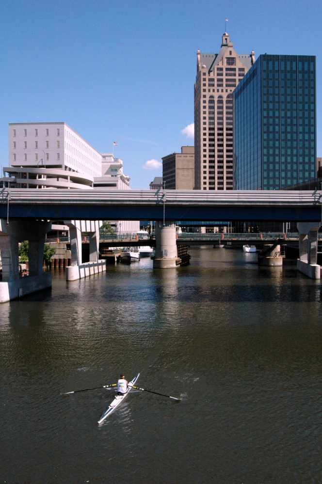 View of downtown Milwaukee with single crew row boat on river
