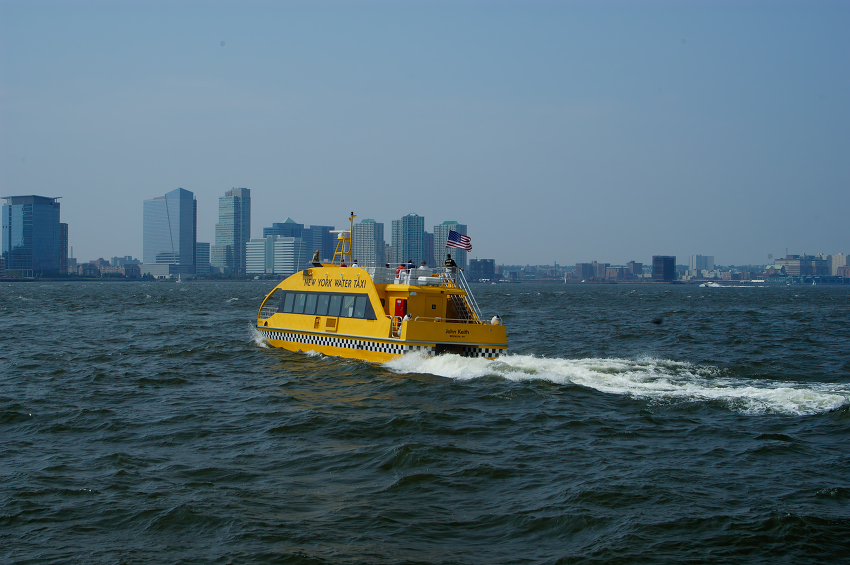yellow new york water taxi cuts through the blue waves of the ha