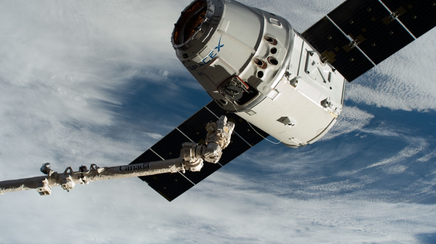 the canadarm2 robotic arm reaches out to grapple the spacex drag ...