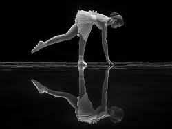 Graceful Dancer Performing on Reflective Surface at Dusk