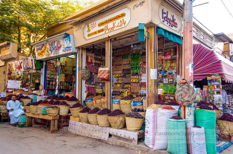 Colorful market stalls line the streets of Aswan showcasing a variety of spices dried fruits and local goods Vendors engage with customers amid vibrant displays