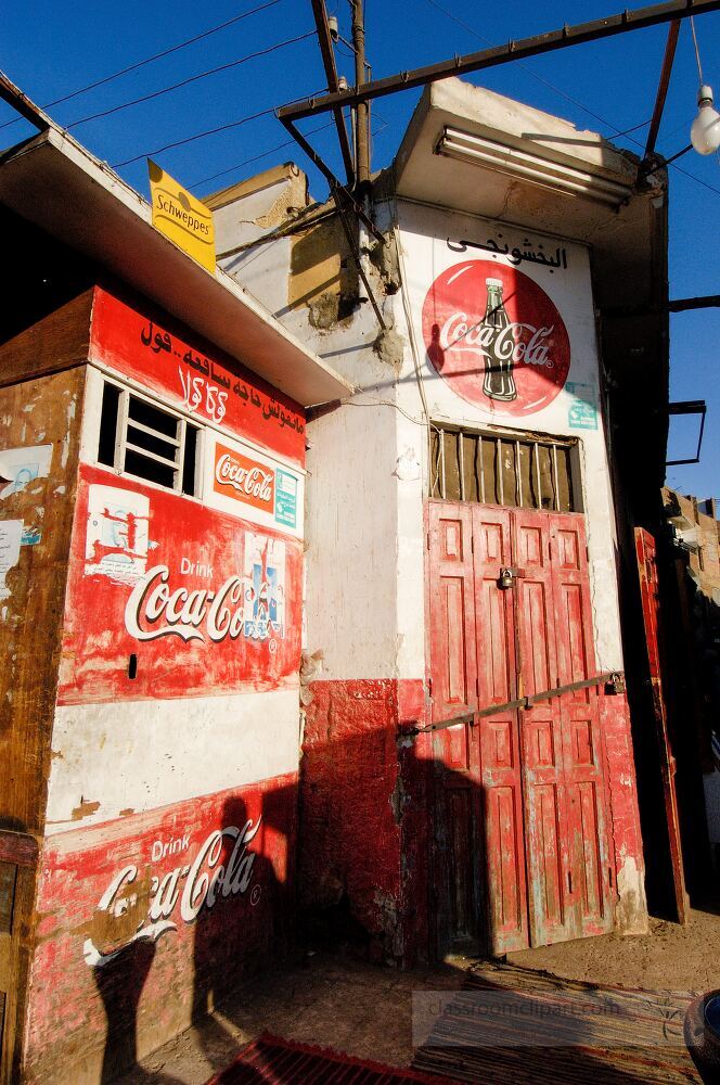 A vibrant shop front in Aswan Egypt displays classic design elements Weathered walls and a wooden door contrast with bright signage capturing local culture and history in a busy neighborhood