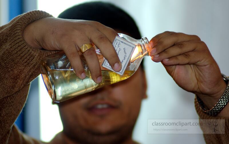 A man carefully pours liquid from a bottle during a cultural ceremony in Aswan Egypt The atmosphere is lively reflecting the rich traditions of the region