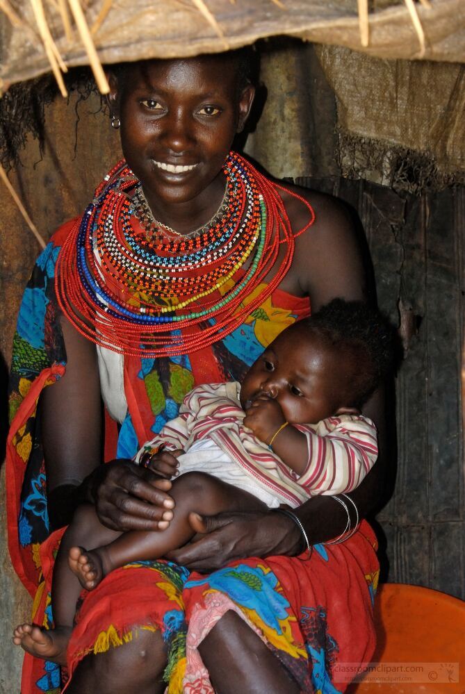 A Samburu mother sits comfortably inside her home joyfully holding her child Adorned in traditional attire and colorful beads she shows the intimate bond and cultural heritage of the Samburu tribe in Kenya