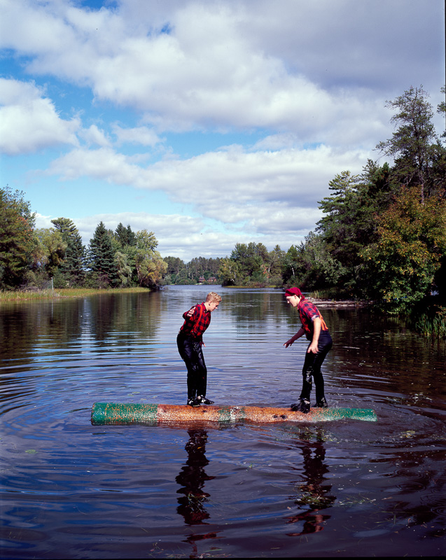 two-young-lumberjacks-ride-a-log-in-the-namekagon-river.jpg