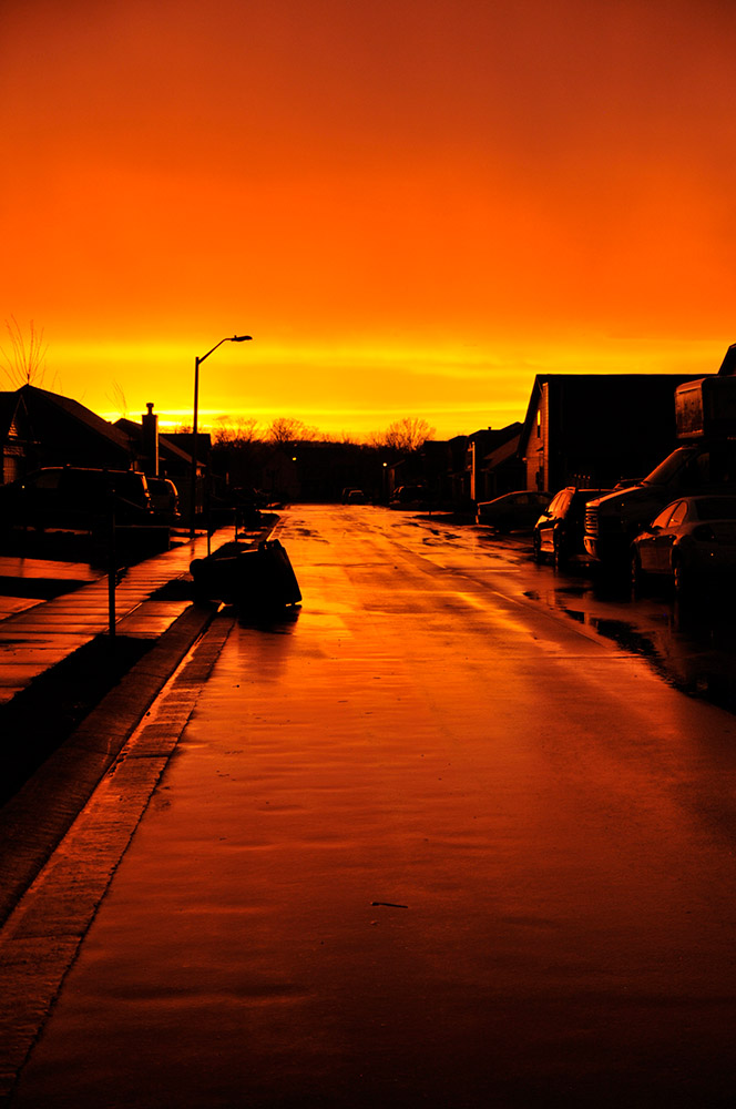 bright-orange-sunset-reflecting-on-street-after-rain.jpg