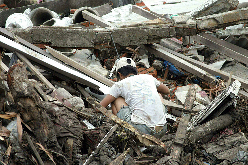 indonesian-man-looks-through-debris.jpg